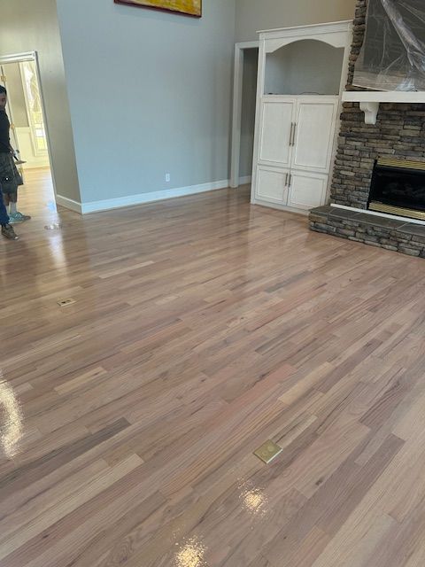 A living room with hardwood floors and a fireplace.