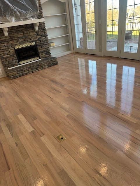 A living room with hardwood floors and a fireplace.