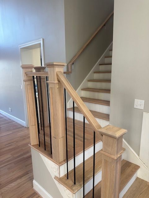 A wooden staircase with a metal railing in a house.