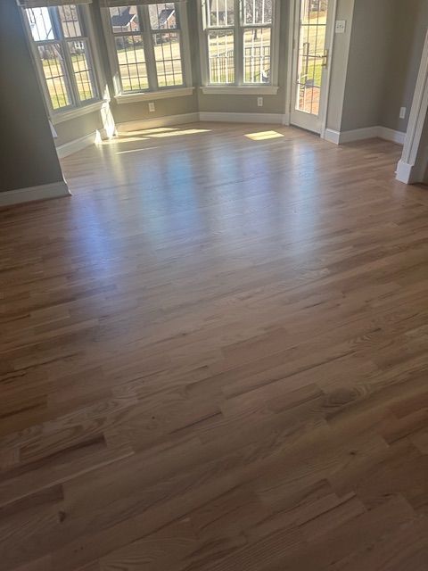 A living room with hardwood floors and a bay window.
