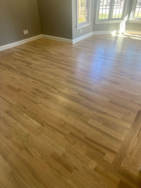 A living room with hardwood floors and a window.