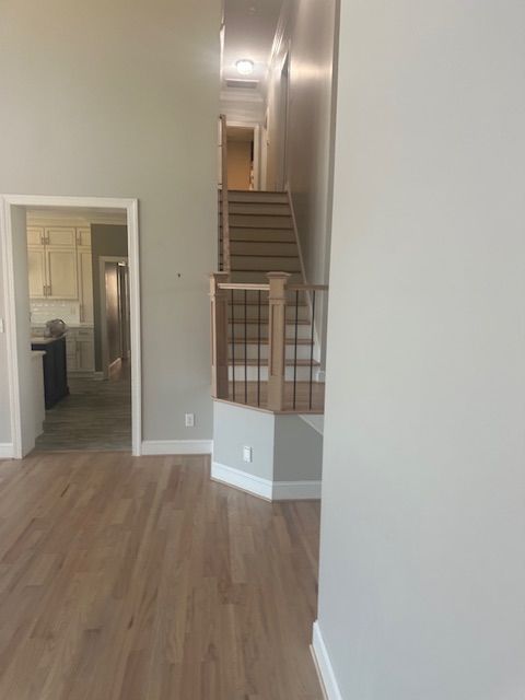 A living room with hardwood floors and stairs leading up to the second floor.