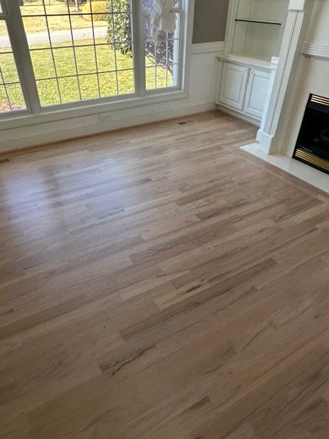 A living room with hardwood floors and a fireplace.