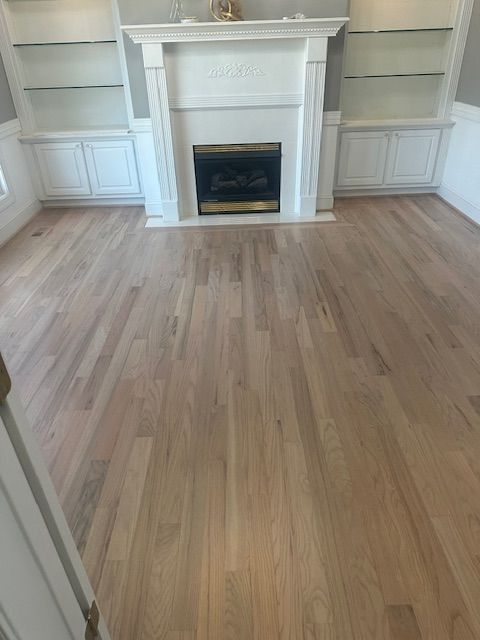 A living room with hardwood floors and a fireplace.