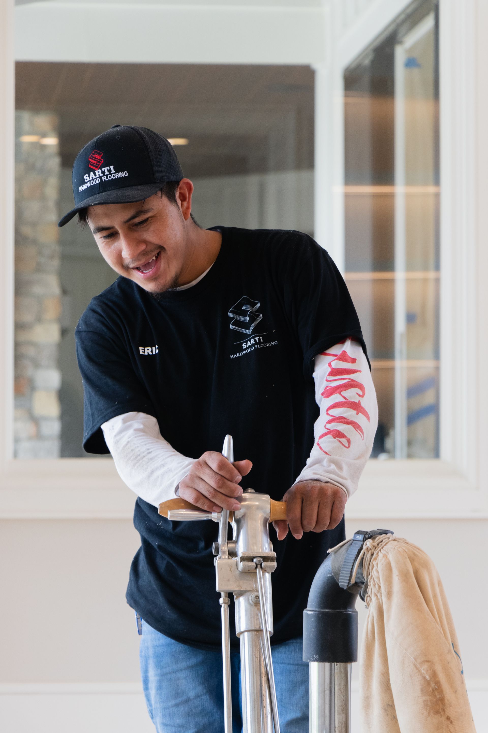 A man in a black shirt is standing next to a vacuum cleaner.