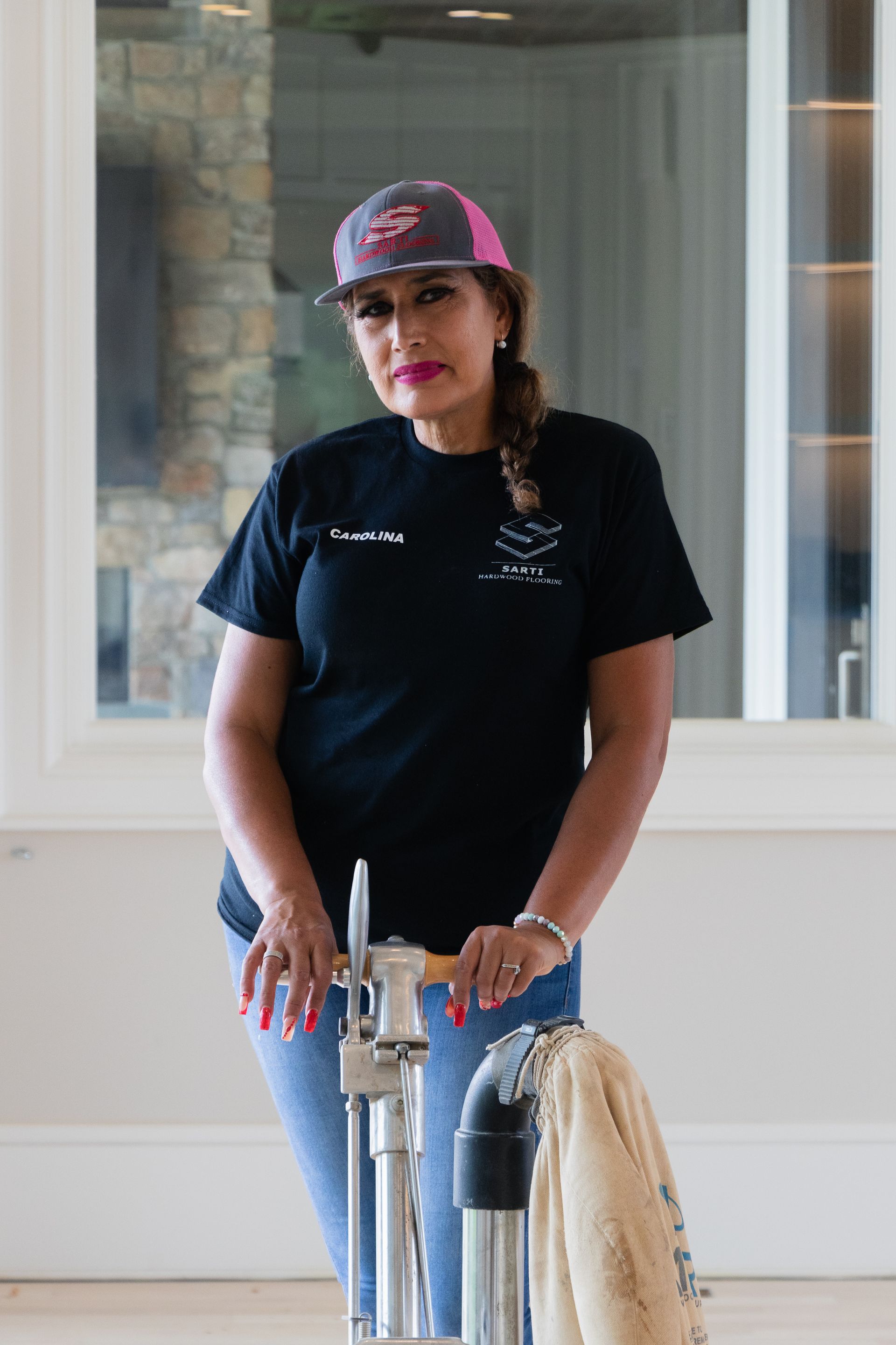 A woman is standing next to a vacuum cleaner in a room.