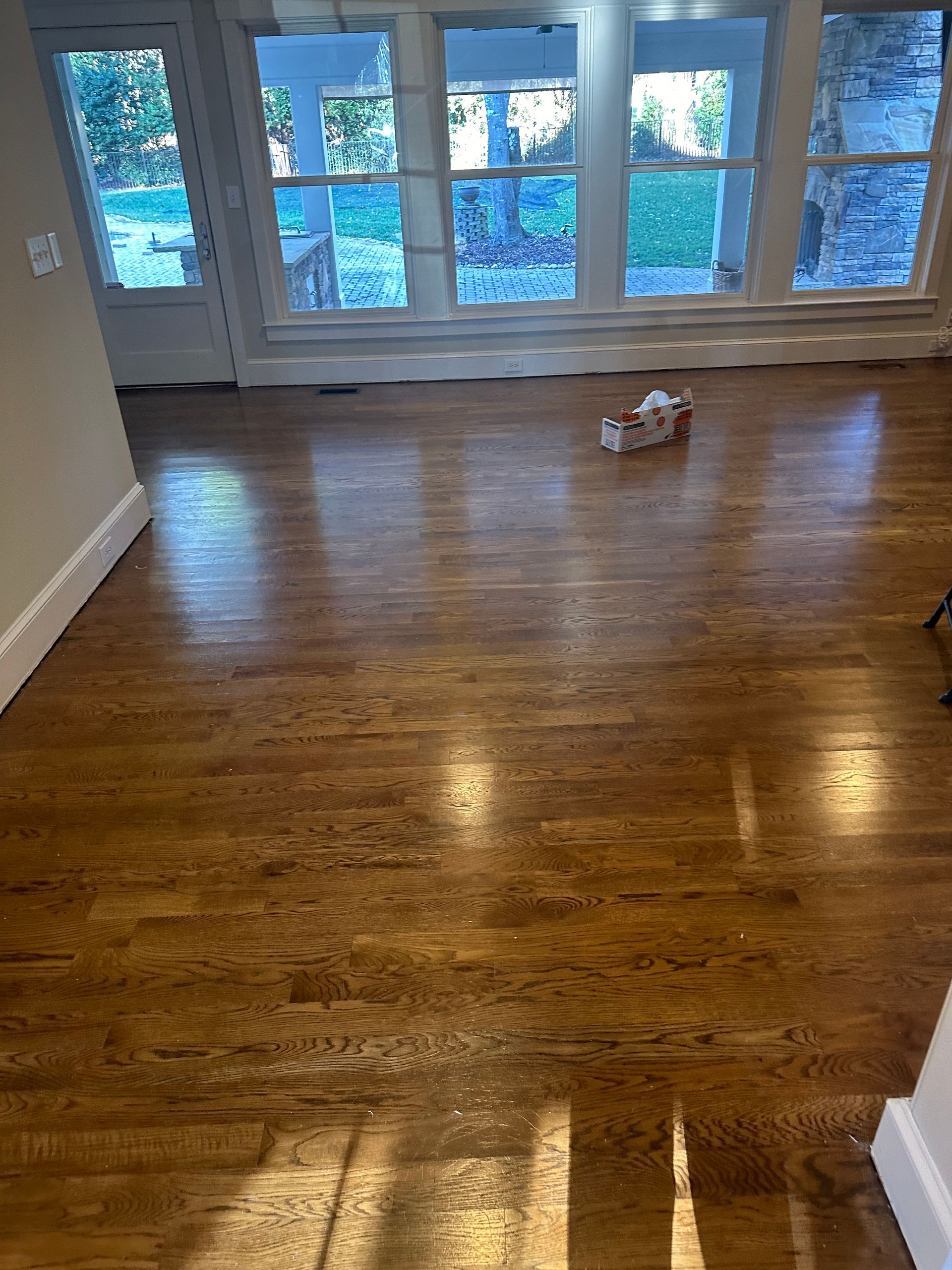 A living room with hardwood floors and lots of windows.