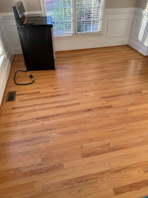 A wooden floor in a living room with a washer and dryer.