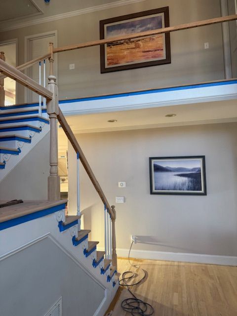 A staircase with a picture on the wall above it