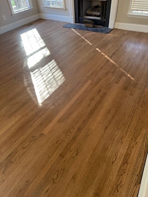 A living room with hardwood floors and a fireplace.