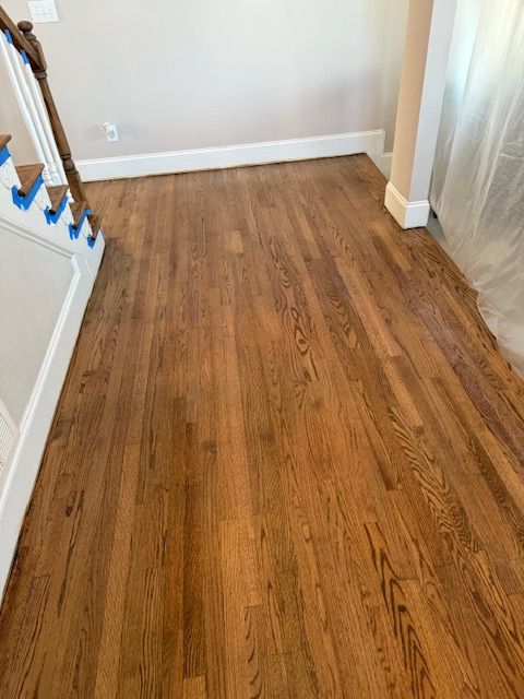 A living room with hardwood floors and stairs.