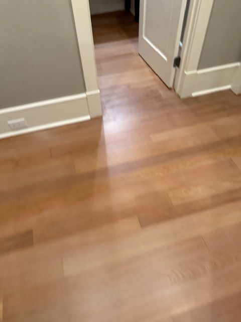 A wooden floor in a room with two doors.