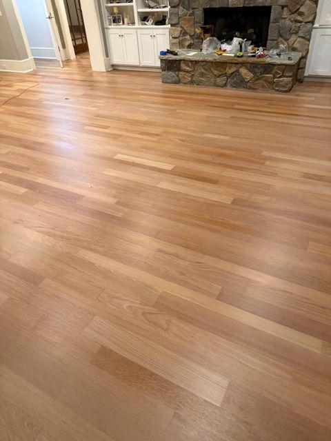 A living room with a wooden floor and a fireplace.