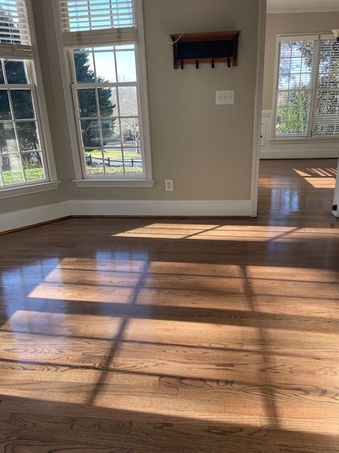 A living room with hardwood floors and lots of windows.