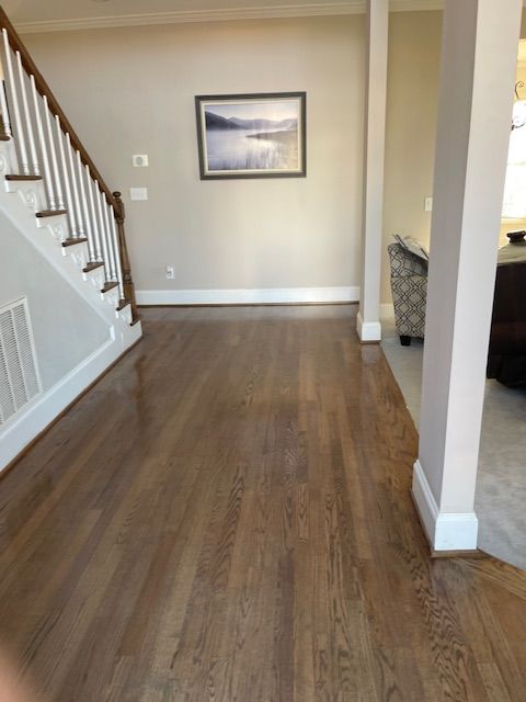 An empty hallway with stairs and a picture on the wall