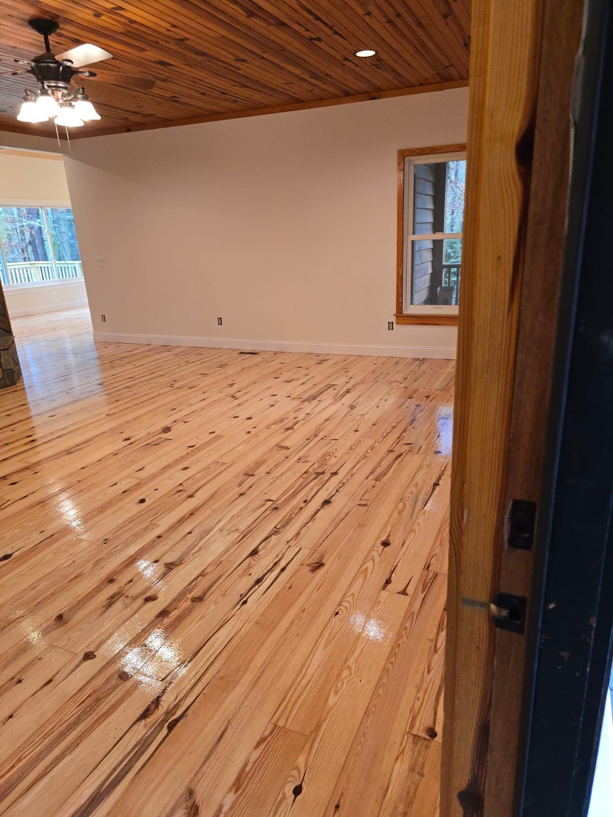 A living room with a wooden floor and a ceiling fan.