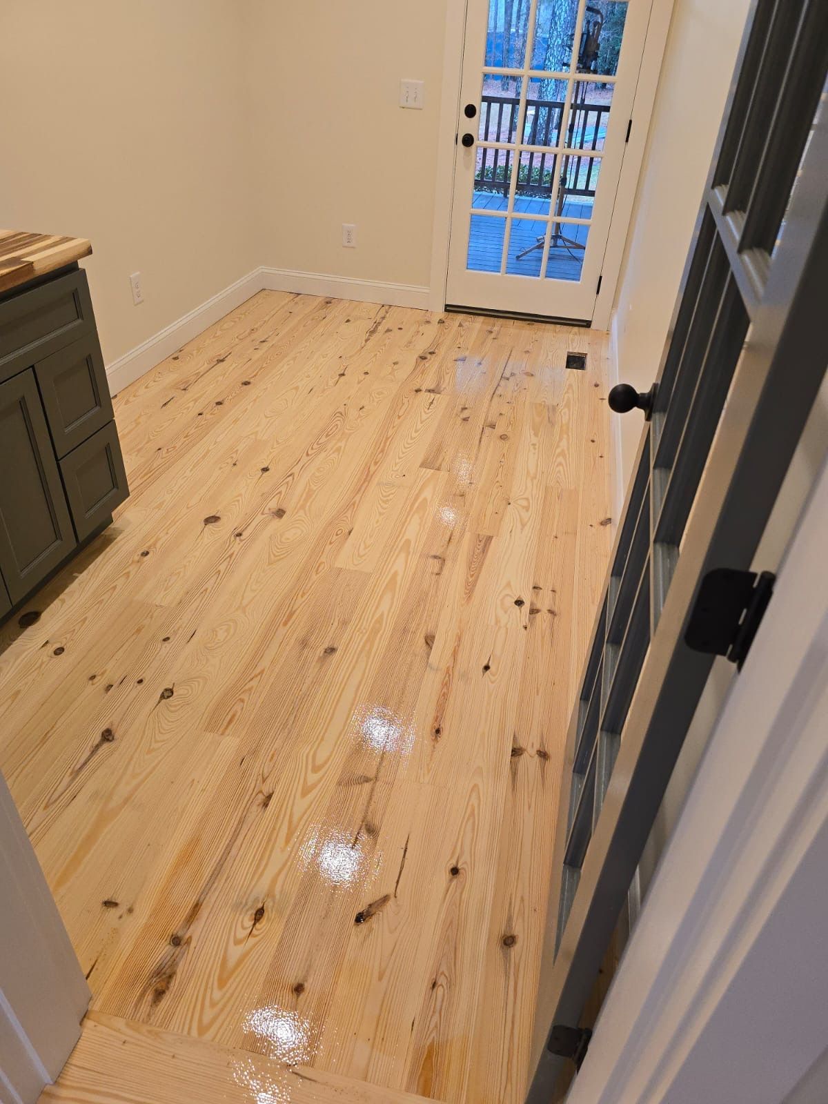 A room with a wooden floor and a french door.