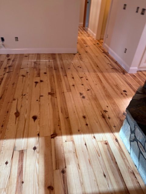 A wooden floor in a room with a fireplace