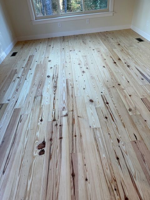 A room with a wooden floor and a window.