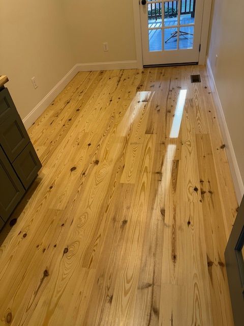 A wooden floor in a room with a sliding glass door.