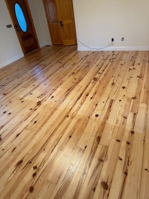 A living room with a wooden floor and a door.