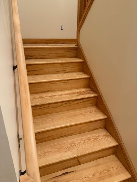 A wooden staircase with a wooden railing and steps