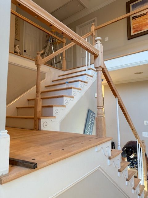 A wooden staircase with a glass railing in a house
