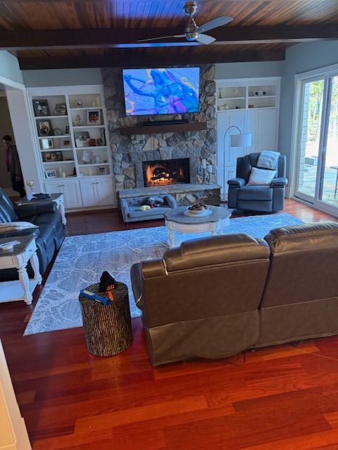 A living room with a fireplace , couch , chair and television.