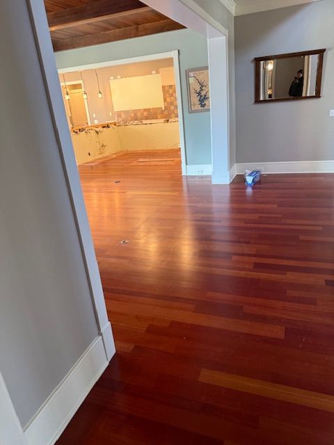 A room with hardwood floors and a mirror on the wall