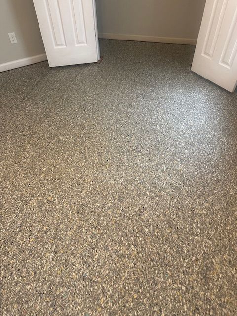 A room with a carpeted floor and two doors.