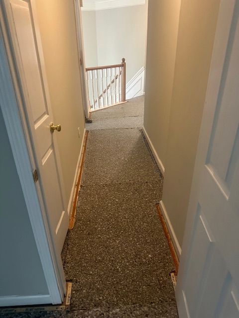 A hallway leading to a staircase in a house.