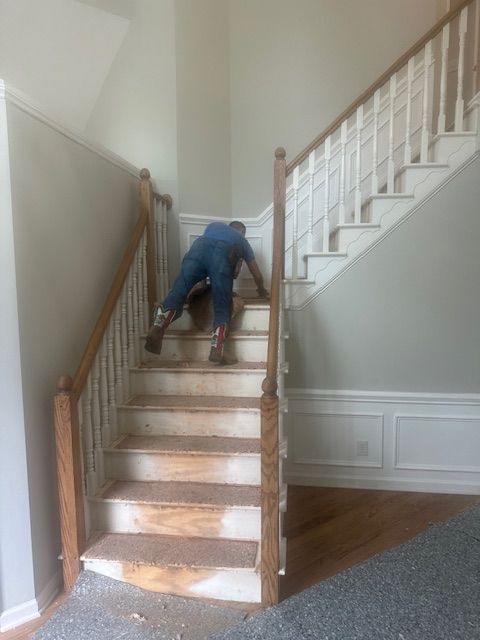 A man is climbing up a set of stairs in a house.