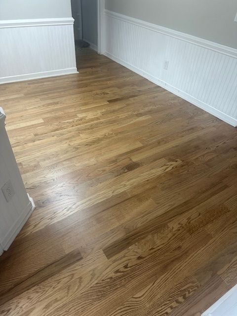 A living room with hardwood floors and white trim.