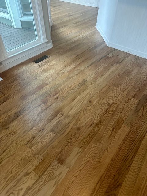A wooden floor in a room with a window.