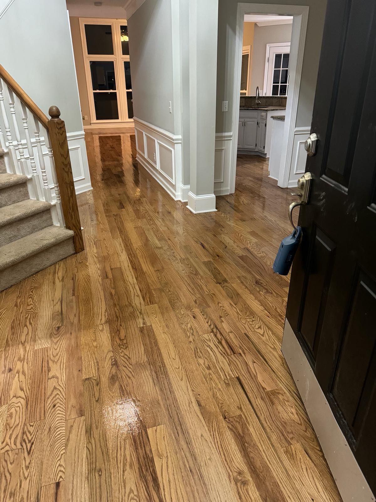 A hallway with hardwood floors and stairs in a house.
