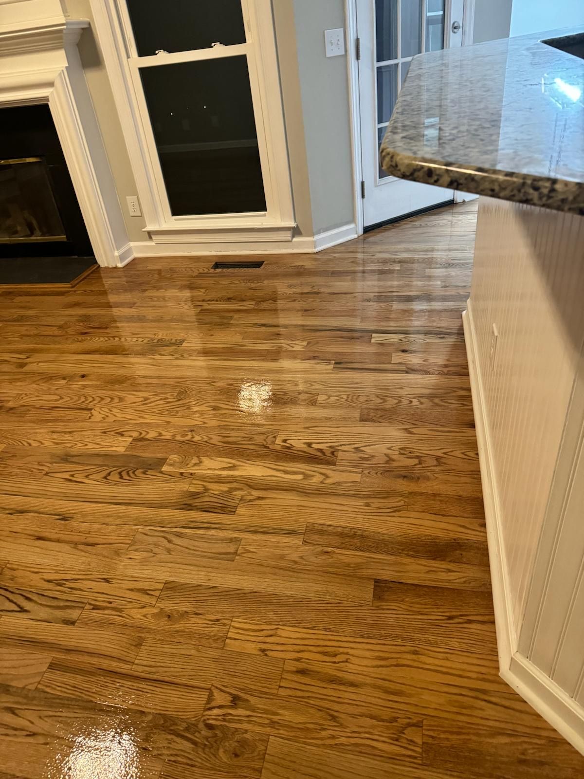 A living room with hardwood floors and a fireplace.