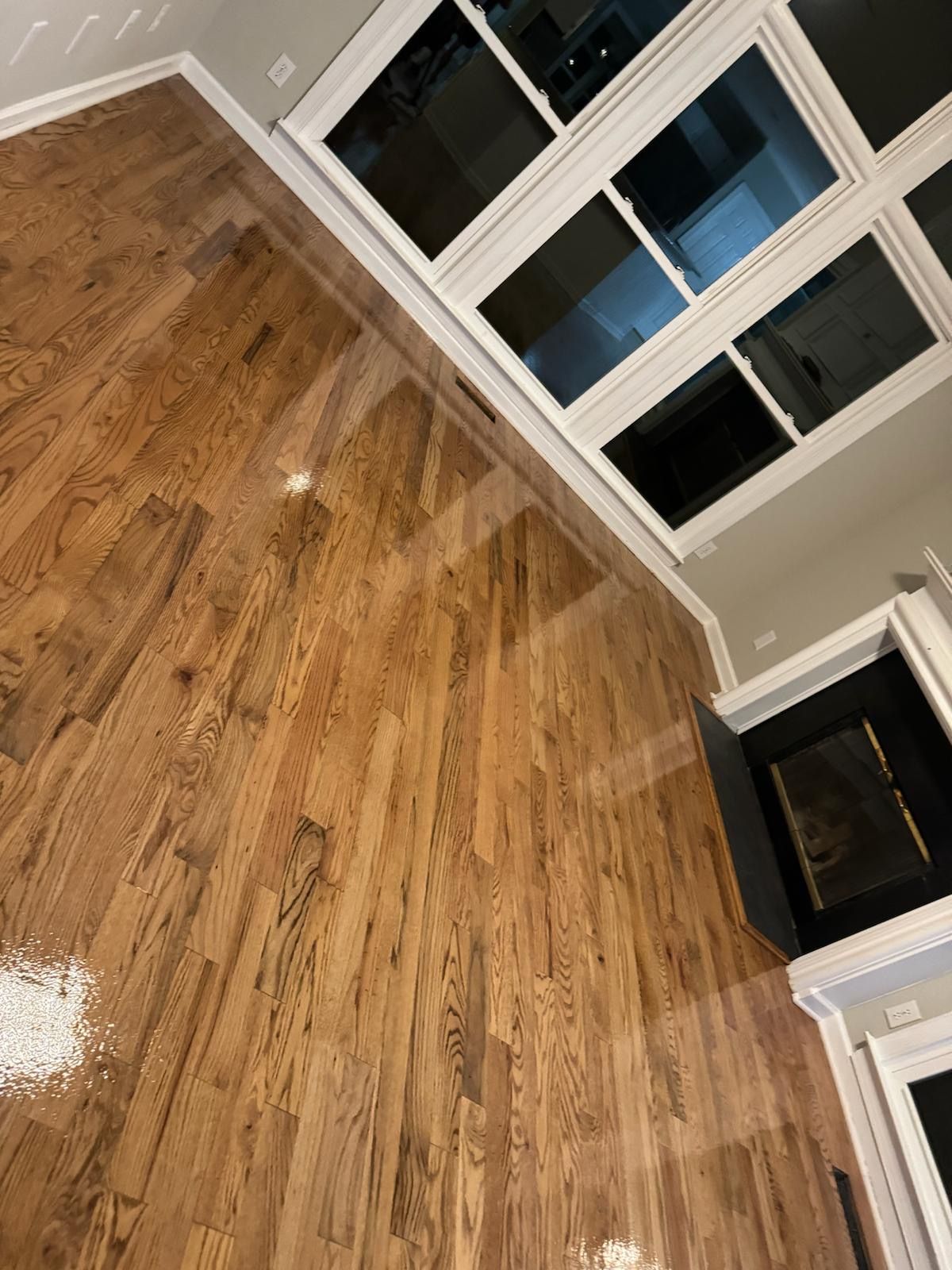 A living room with hardwood floors and a fireplace.