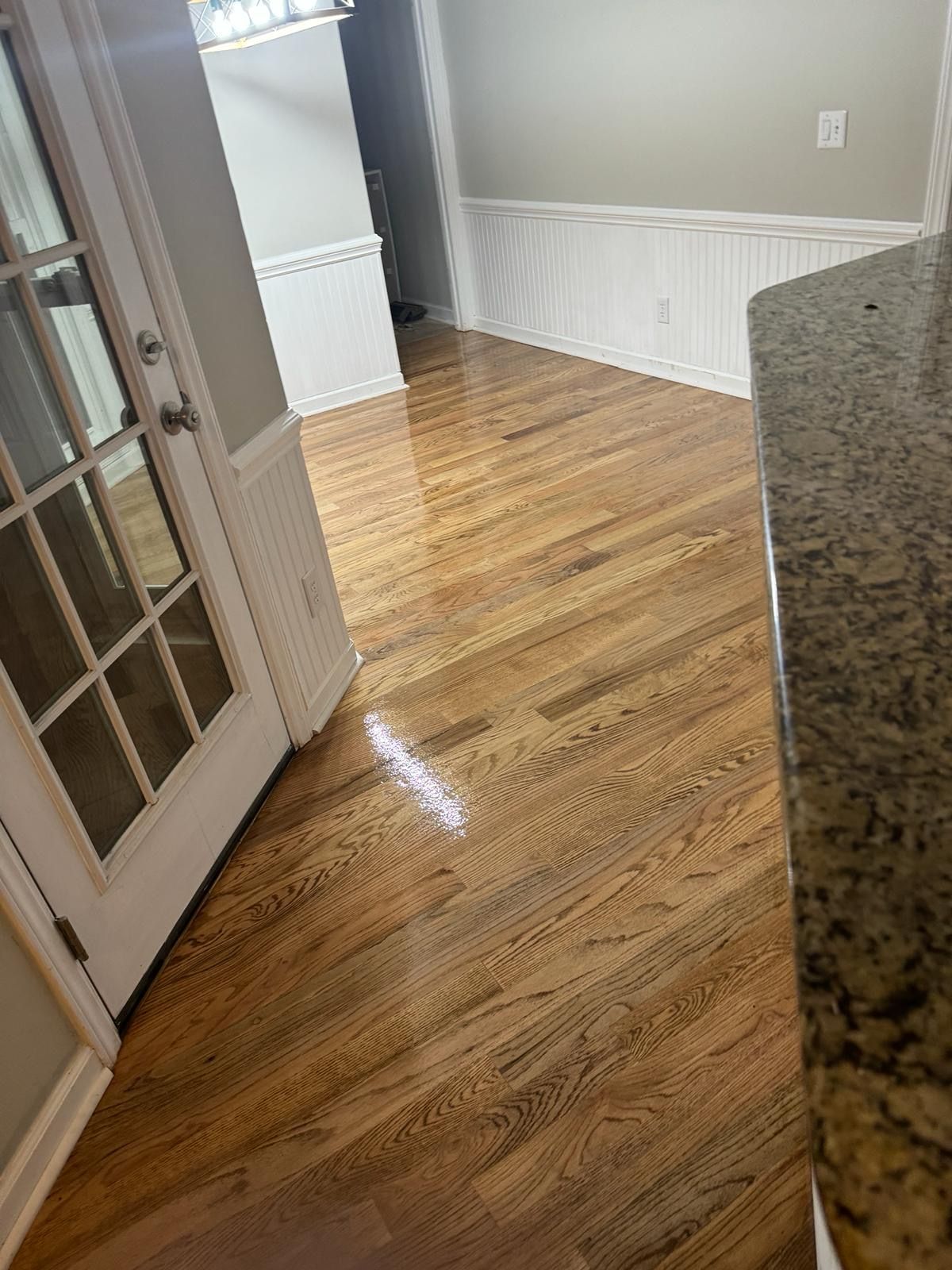 A kitchen with hardwood floors and a granite counter top.
