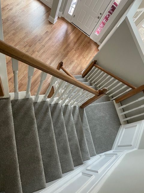 A staircase with a wooden railing and a carpeted staircase
