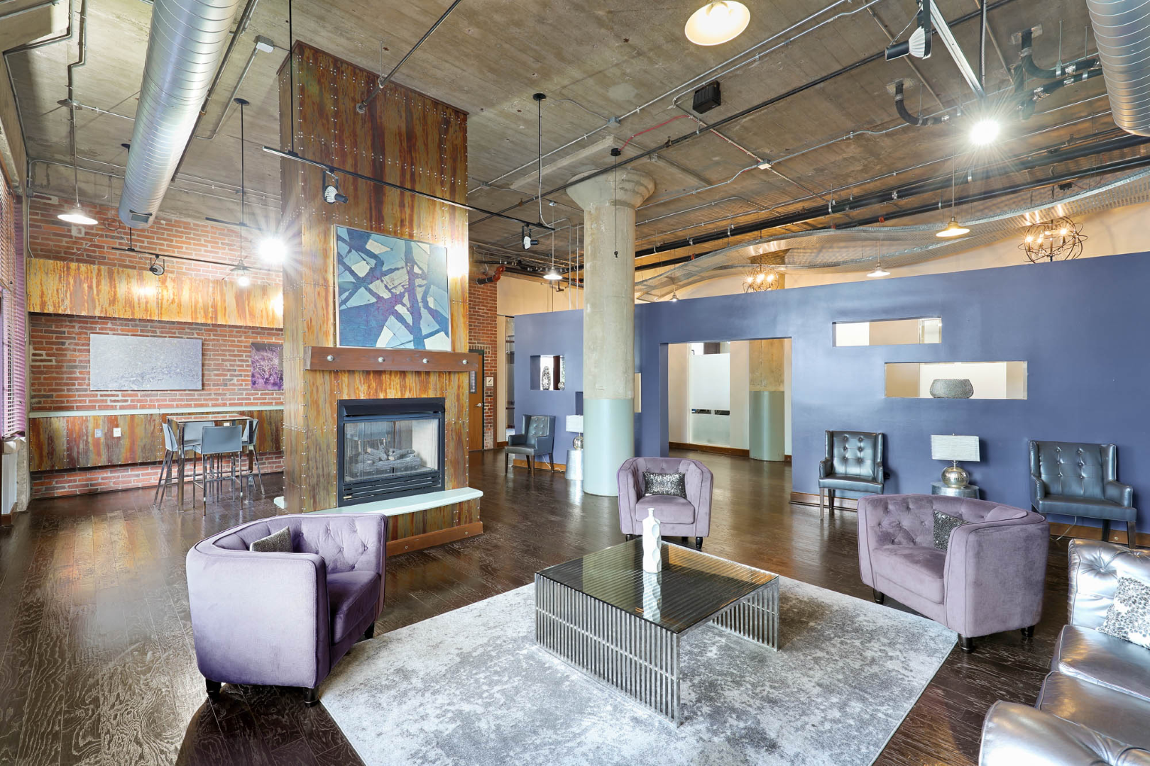 Clubhouse with purple chairs and a fireplace.