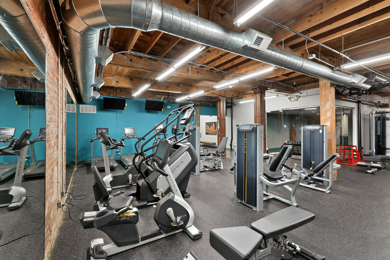 A large gym filled with lots of exercise equipment.