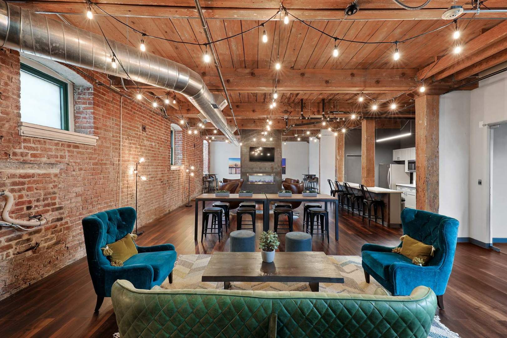 Clubroom with a green couch, blue chairs, and a table.