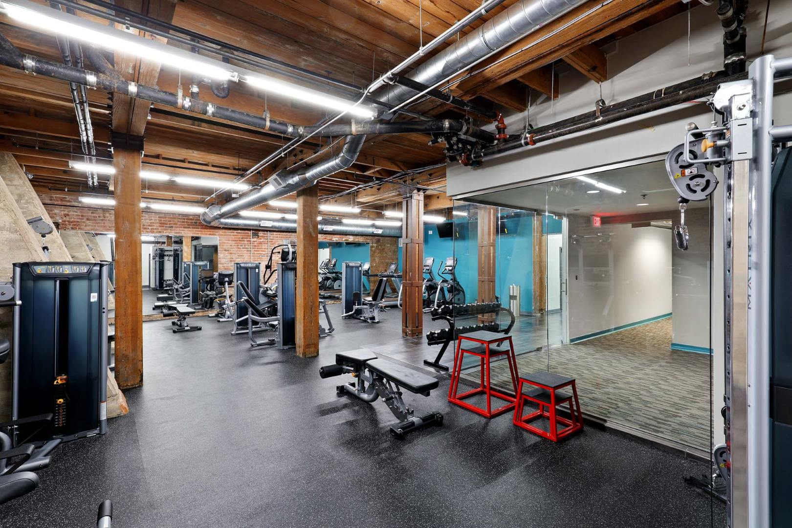 A large gym with a lot of equipment and a mirror.