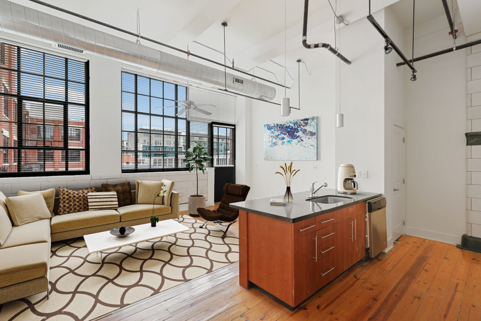 A living room with a couch , coffee table , and kitchen.