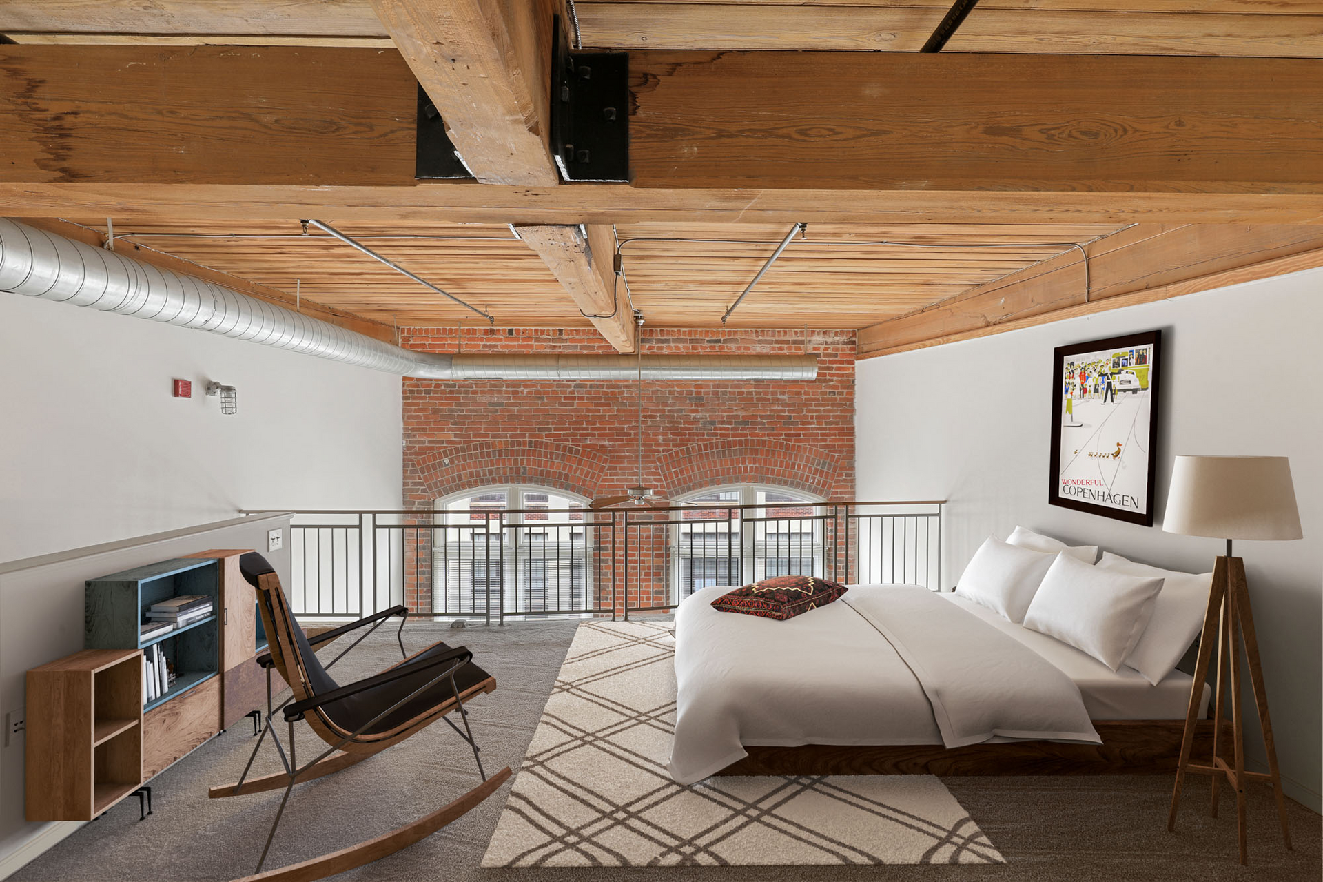 A bedroom with a large bed and a rocking chair.