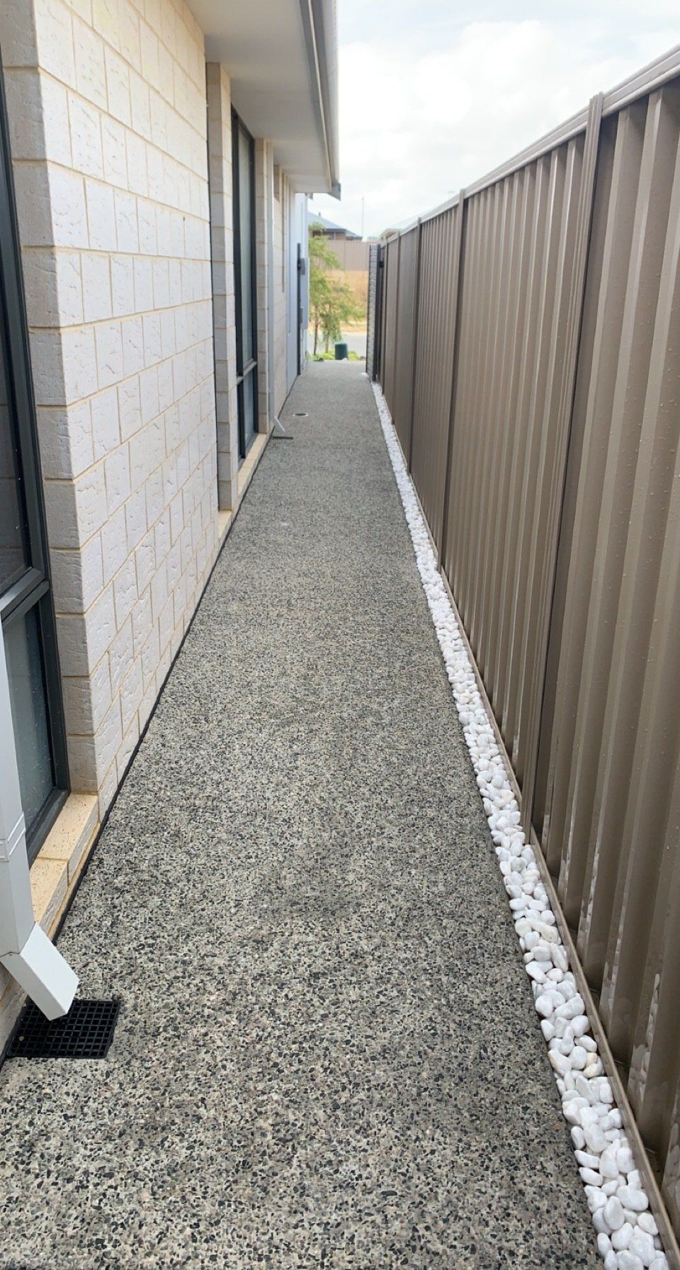 Exposed aggregate concrete down the side of a house