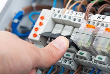 Hand of an electrician turning on a fusebox