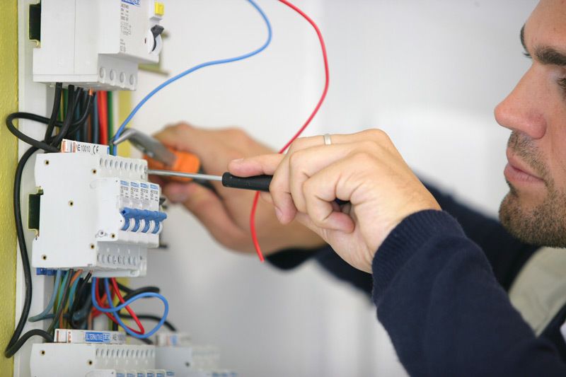 Certified electrician carefully working on a circuit breaker