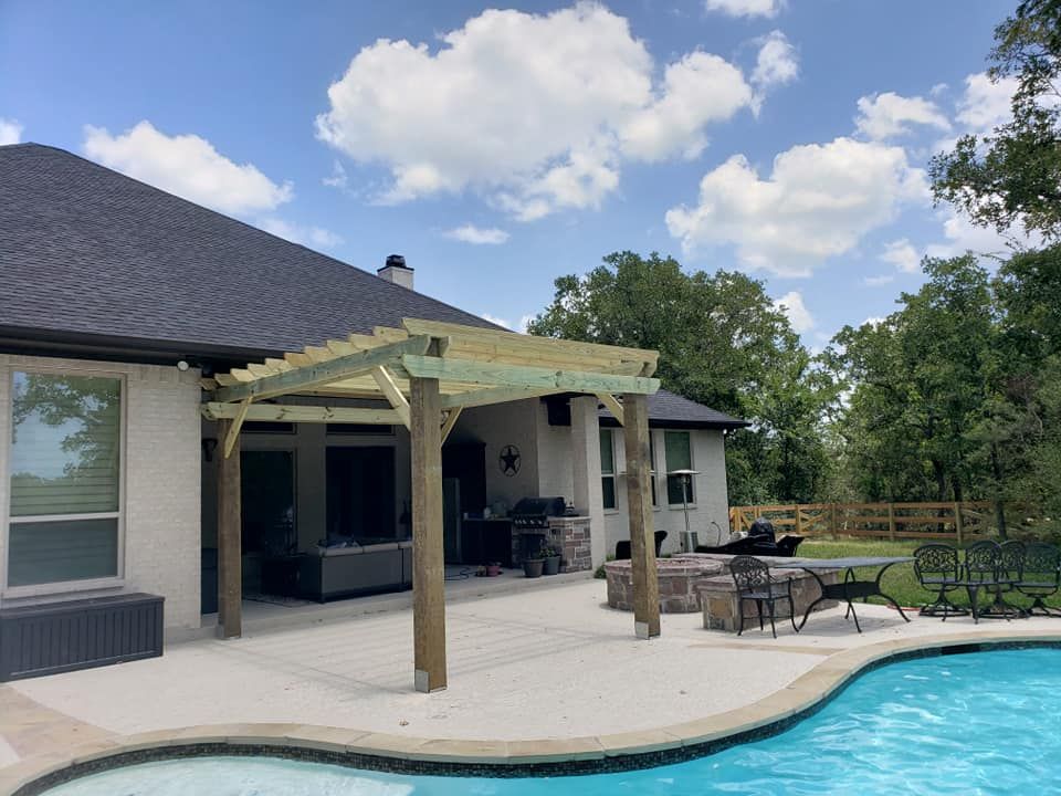 A house with a pool and a pergola in front of it.