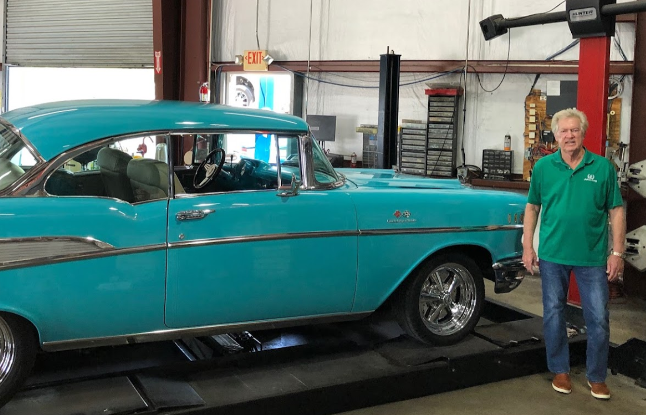 Man stands by a teal classic car in a garage | Crown Car Care